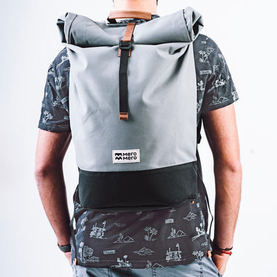 men wearing a rolled light grey recycled plastic backpack named Squamish from the brand Mero Mero