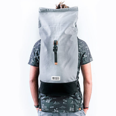 men wearing a unrolled grey recycled backpack