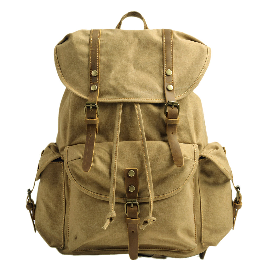 Military canvas backpack in khaki tan with oversized leather flap, twin leather strap closures with brass snaps, large front cargo pocket and side cargo pockets — Montreal