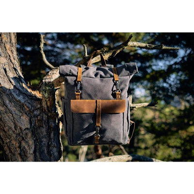 a retro canvas rucksack hanging on a tree