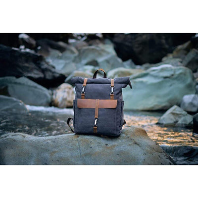 a retro canvas rucksack on a river bed rock