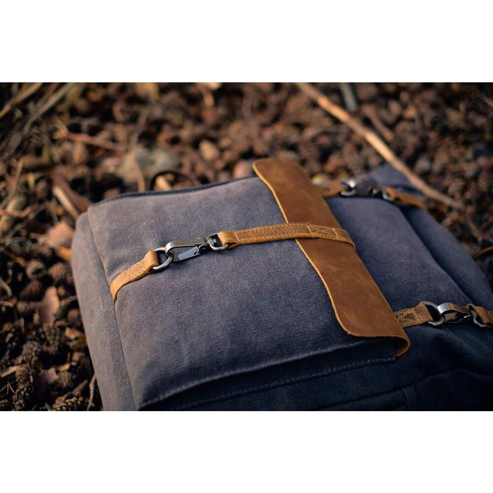 canvas rucksack on a floor of cone pine