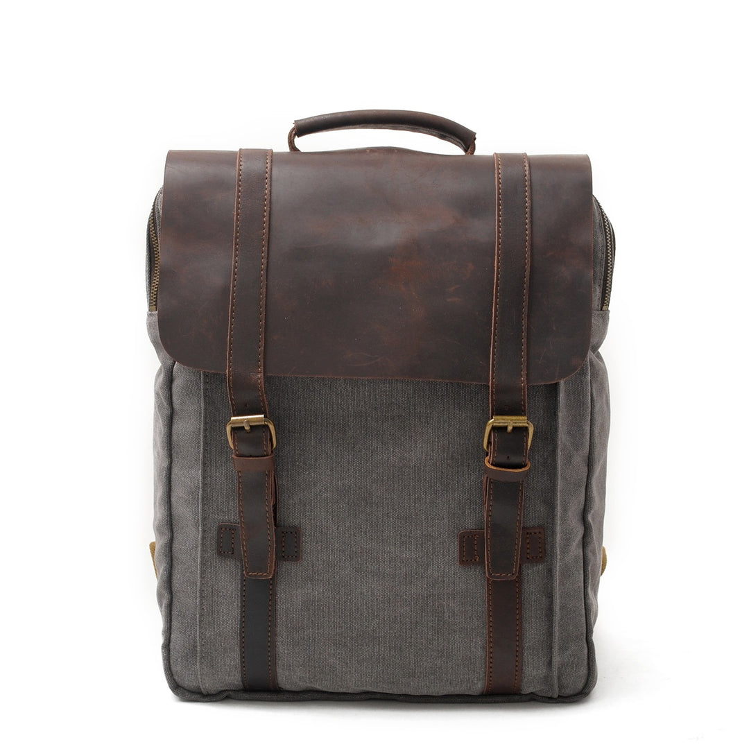 Vintage bookbag in dark grey waxed canvas with full-grain leather flap, twin leather straps and brass buckles, Eiken Nuuk model